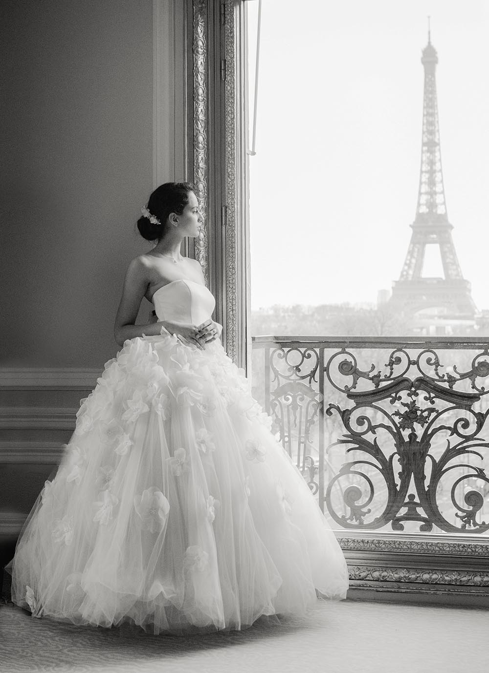 Une mariée se trouve à l'hotel plaza athénée Paris et regarde la tour Eiffel
